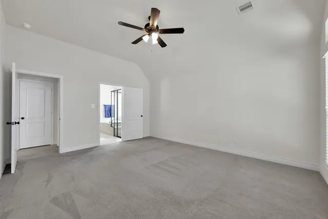 an empty room with a ceiling fan and a window