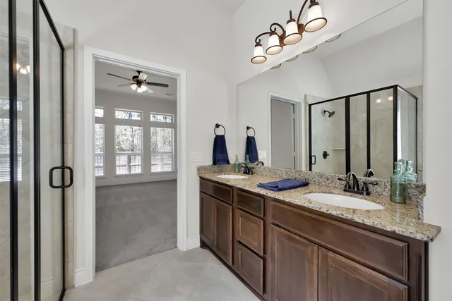 a bathroom with a granite countertop sink a large mirror and a shower