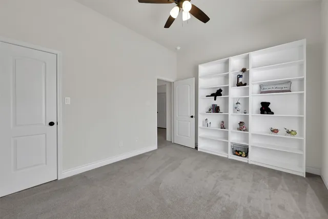 a view of an empty room with cabinet and windows