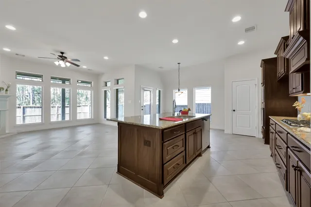 a large kitchen with stainless steel appliances a sink and cabinets