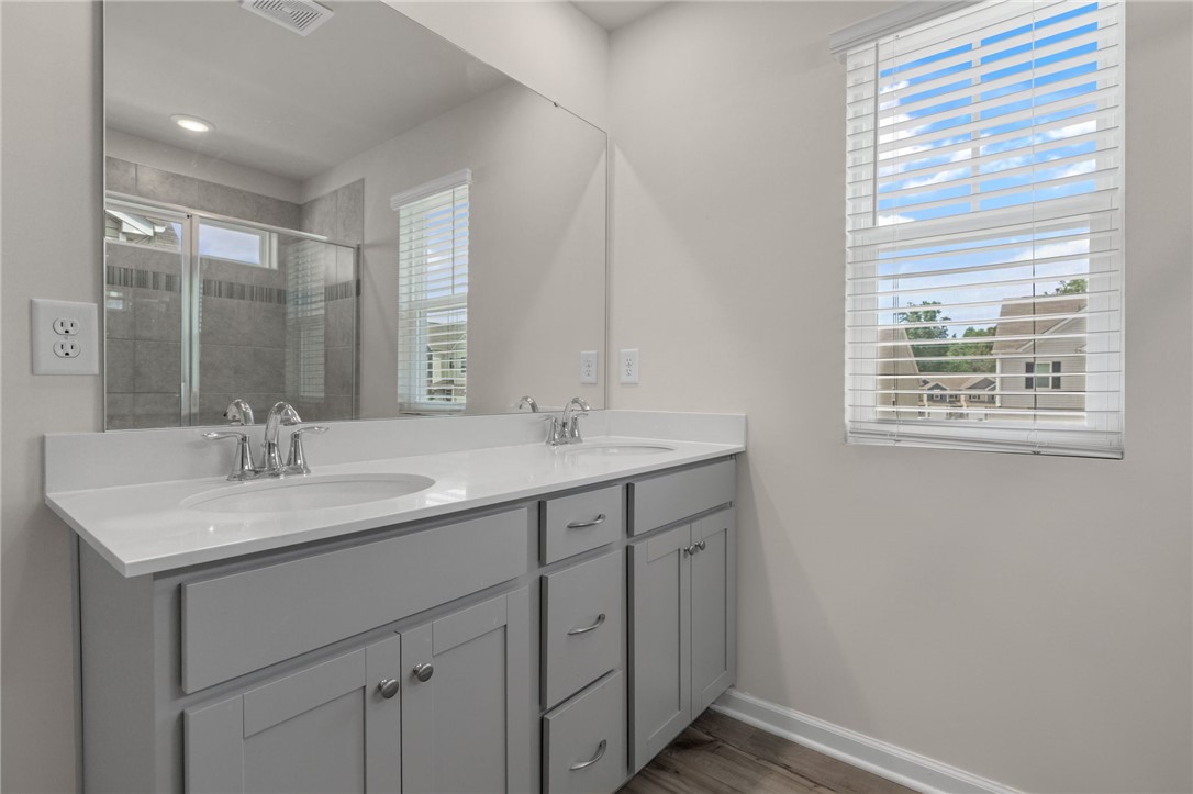 432 Bee Cv Way Pendleton, SC 29670 - Photo 20 of 39 This spacious bathroom features a double vanity and a glass-enclosed shower, offering both comfort and practicality.
