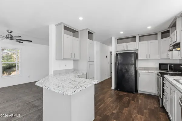 a view of a kitchen with white cabinets and stainless steel appliances