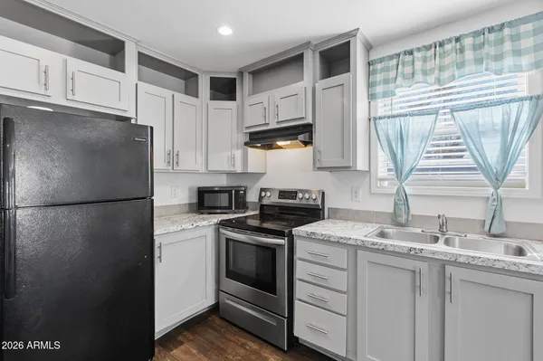a kitchen with stainless steel appliances cabinets and wooden floor