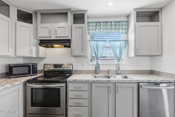 a kitchen with stainless steel appliances white cabinets and a refrigerator