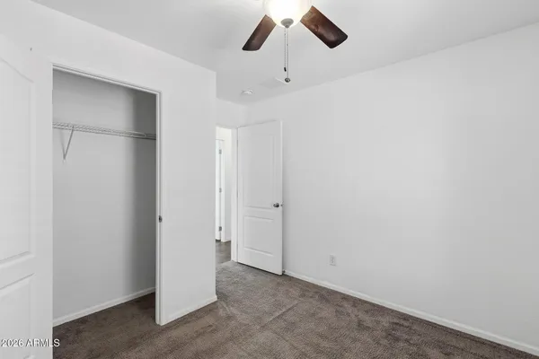 an empty room with windows and fan
