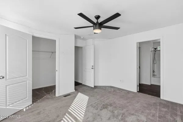a view of a livingroom with a ceiling fan and window