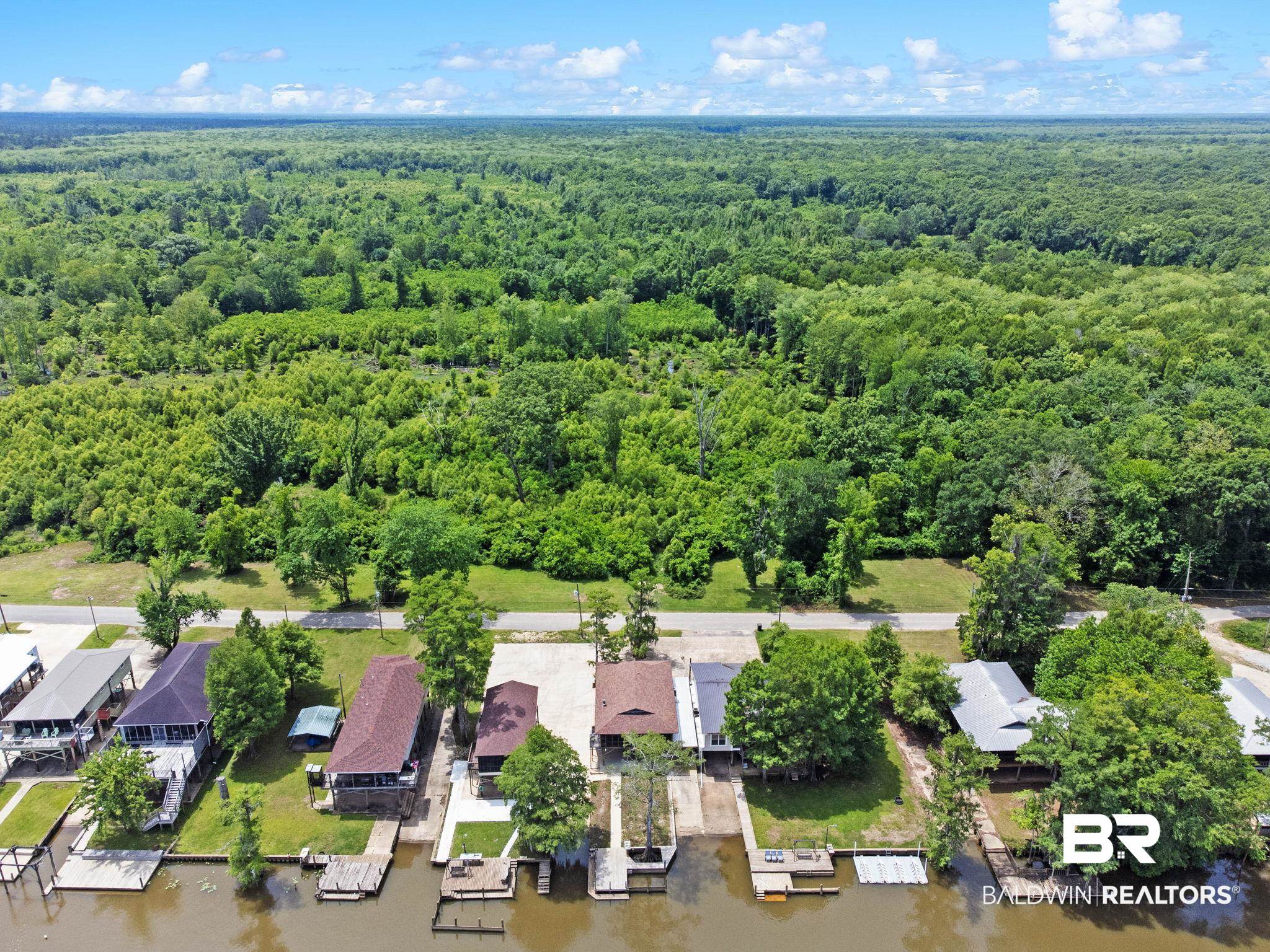 8153 Bryant's Lndg Road Stockton, AL 36579 - Photo 83 of 87 Waterfront property featuring a private boat launch, a covered boat slip with an attached pier, and a spacious rear deck