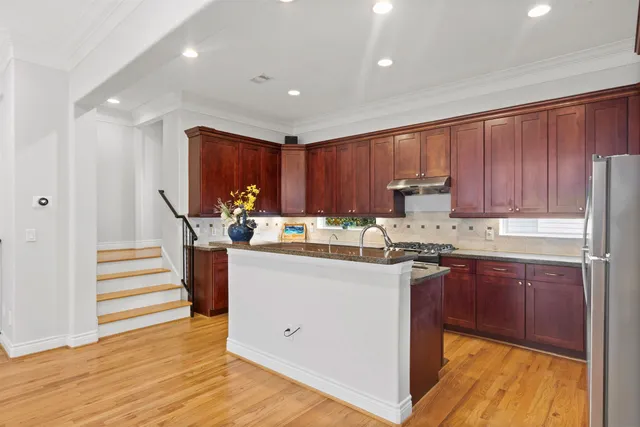 a kitchen with granite countertop a sink stove and cabinets
