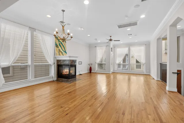 a view of a room with wooden floor fireplace and windows