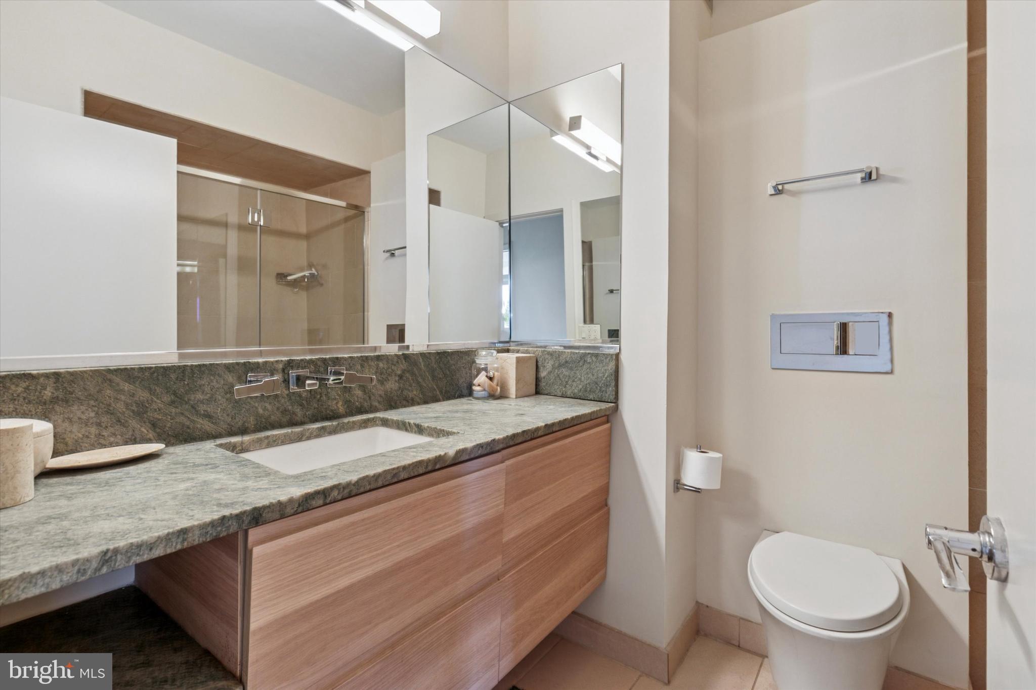 191 Presidential Boulevard, Unit R605 Bala Cynwyd, PA 19004 - Photo 21 of 35 a bathroom with a granite countertop toilet sink and mirror