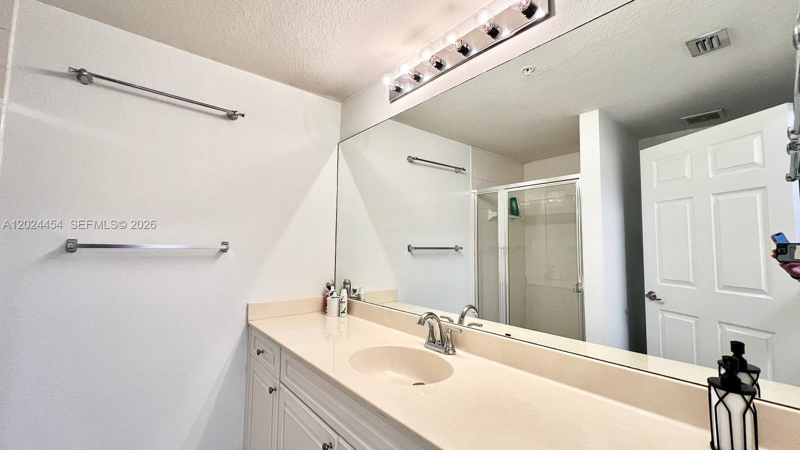 2727 Anzio Court, Unit 106 Palm Beach Gardens, FL 33410 - Photo 18 of 43 a bathroom with a sink vanity and a mirror