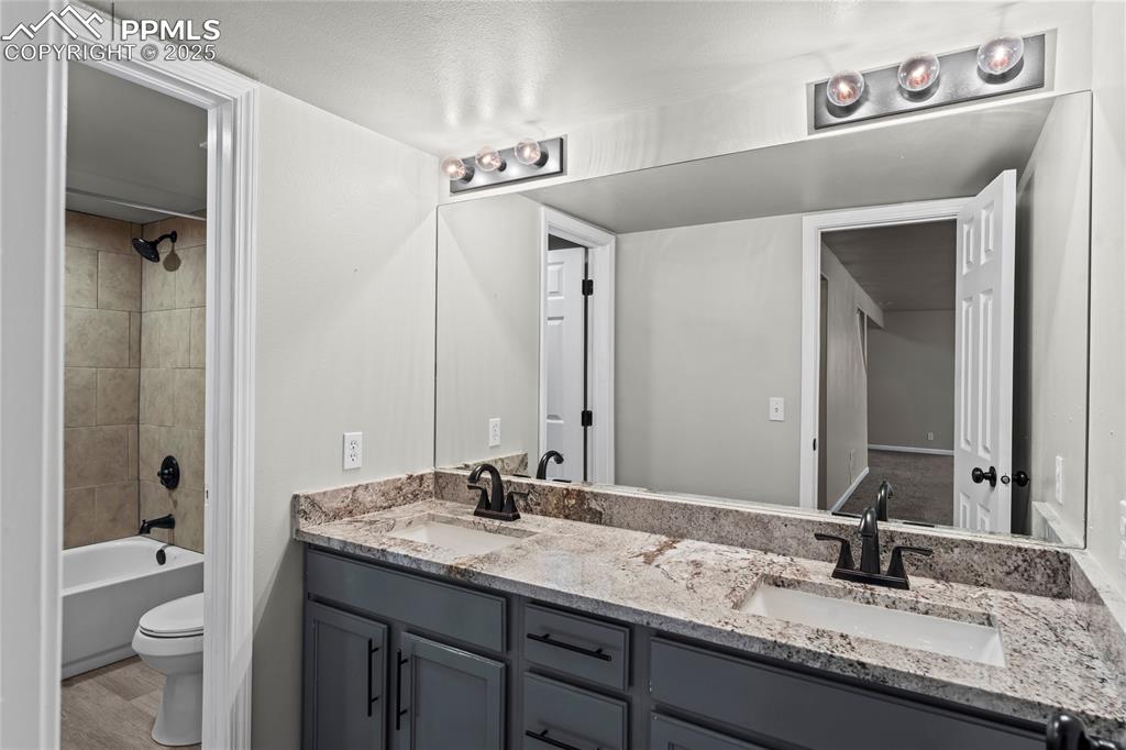8168 Oliver Road Peyton, CO 80831 - Photo 22 of 42 a bathroom with a granite countertop sink toilet and shower
