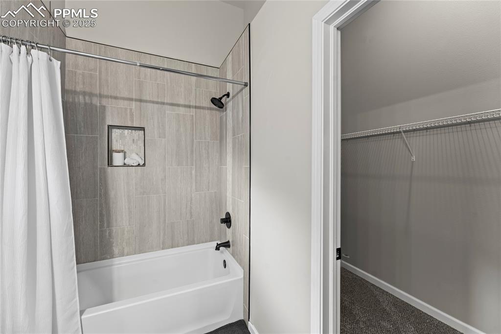 8168 Oliver Road Peyton, CO 80831 - Photo 28 of 42 a bathroom with a bathtub a shower and a shower
