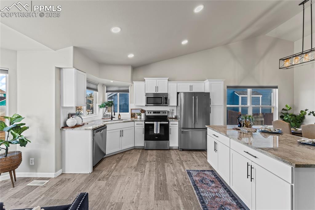 8168 Oliver Road Peyton, CO 80831 - Photo 8 of 42 a large kitchen with a sink and stainless steel appliances