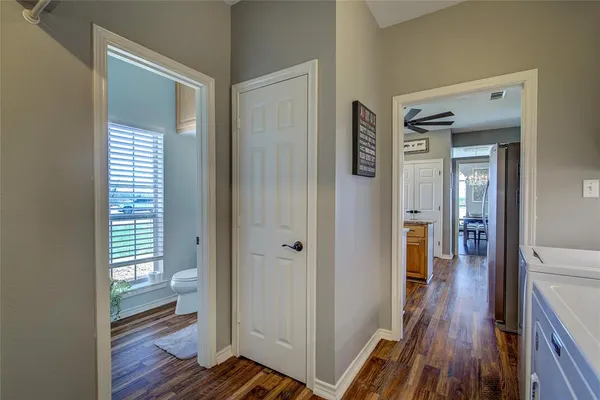 a view of a hallway with wooden floor and closet