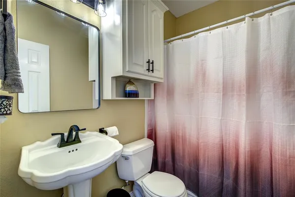 a bathroom with a sink a toilet and a mirror