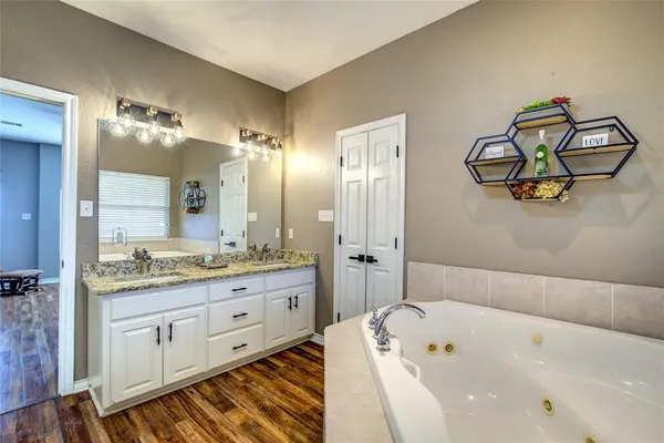 a bathroom with a tub a sink and mirror