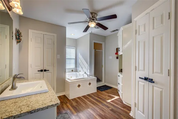 a spacious bathroom with a granite countertop sink and a mirror