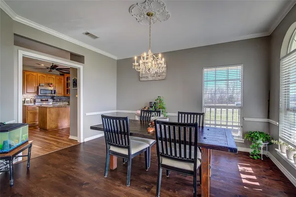 a view of a dining room with furniture wooden floor and chandelier