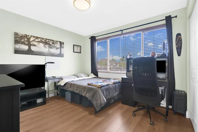 a bedroom with a bed and wooden floor