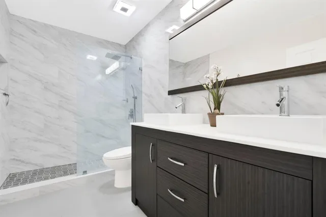a bathroom with a double vanity sink toilet and a mirror