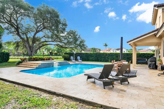 a view of a swimming pool with chair and tables