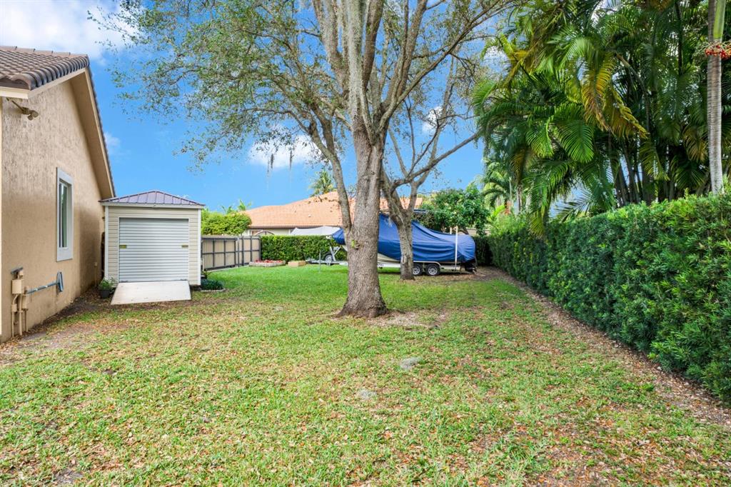 14809 Southwest 154th Court Miami, FL 33196 - Photo 27 of 30 a yellow house with a yard and large trees