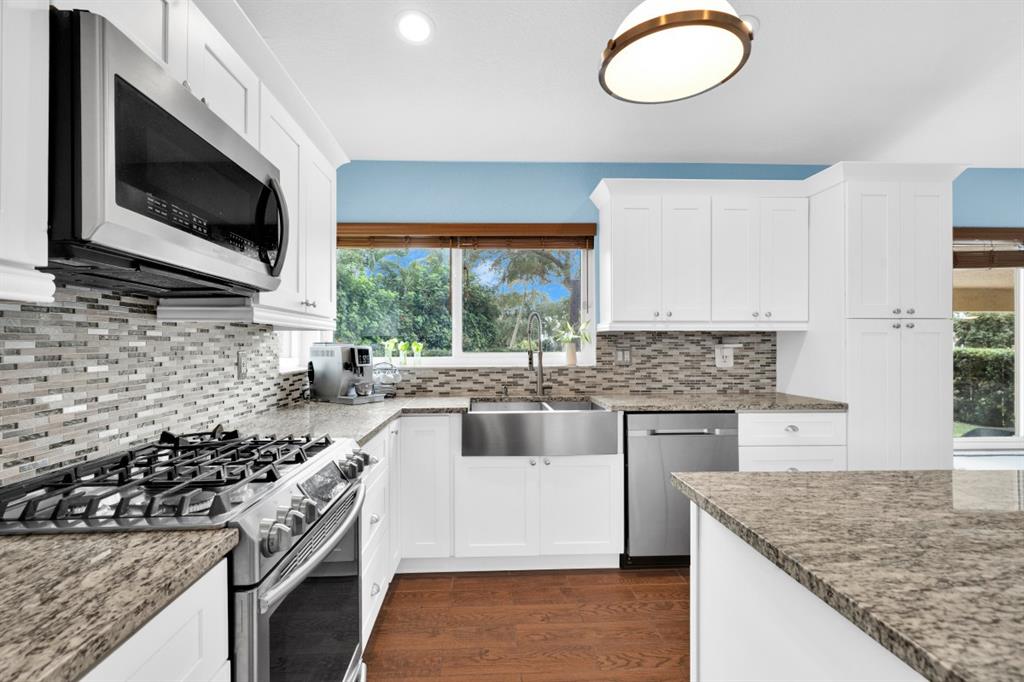 14809 Southwest 154th Court Miami, FL 33196 - Photo 9 of 30 a kitchen with stainless steel appliances granite countertop a sink and a stove