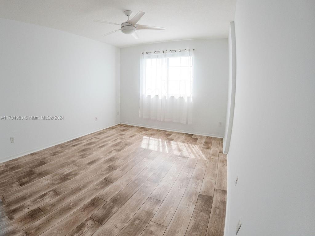 233 South Federal Highway, Unit 723 Boca Raton, FL 33432 - Photo 2 of 35 an empty room with wooden floor ceiling fan and windows