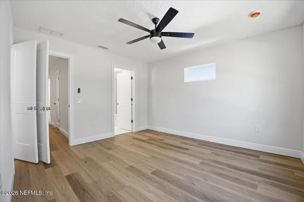 a view of empty room with wooden floor