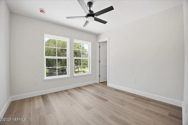 an empty room with wooden floor and windows