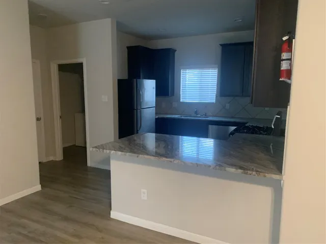 a kitchen with stainless steel appliances granite countertop a refrigerator and a sink