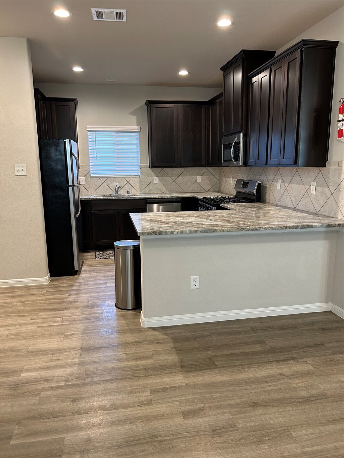 6511 Wenlock Drive Houston, TX 77048 - Photo 4 of 23 a kitchen with stainless steel appliances granite countertop a sink a stove and a wooden floors