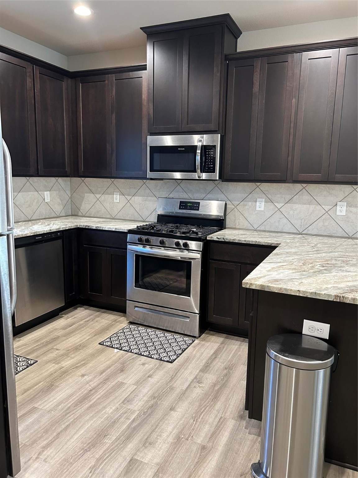 6511 Wenlock Drive Houston, TX 77048 - Photo 7 of 23 a kitchen with wooden cabinets a sink and a stove