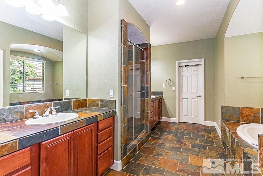 8170 Willow Ranch Trail Reno, NV 89523 - Photo 15 of 23 a spacious bathroom with a double vanity sink a mirror and a shower