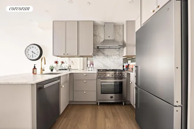 a kitchen with stainless steel appliances a stove a sink and a refrigerator