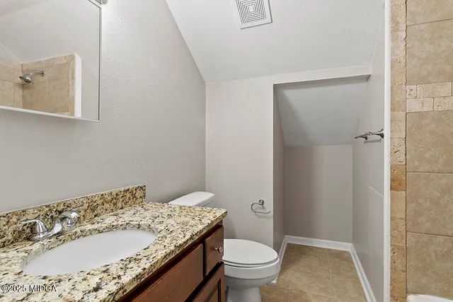 a view of an empty room and chandelier fan