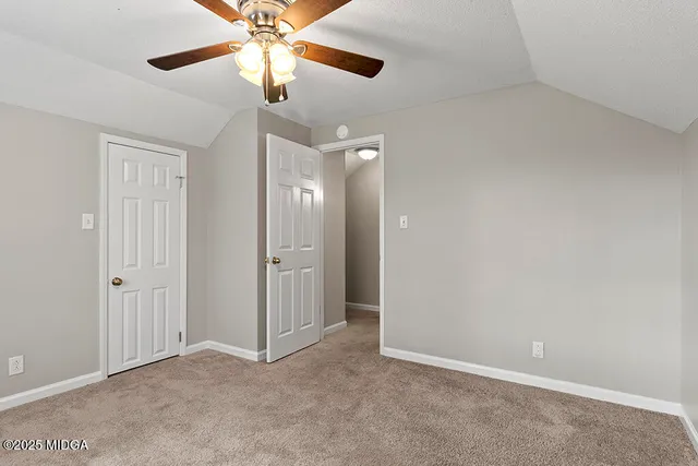an empty room with a window and a ceiling fan