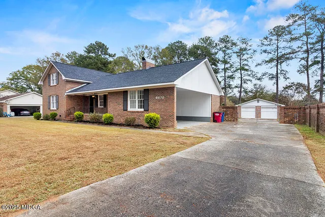 a front view of a house with a yard and road