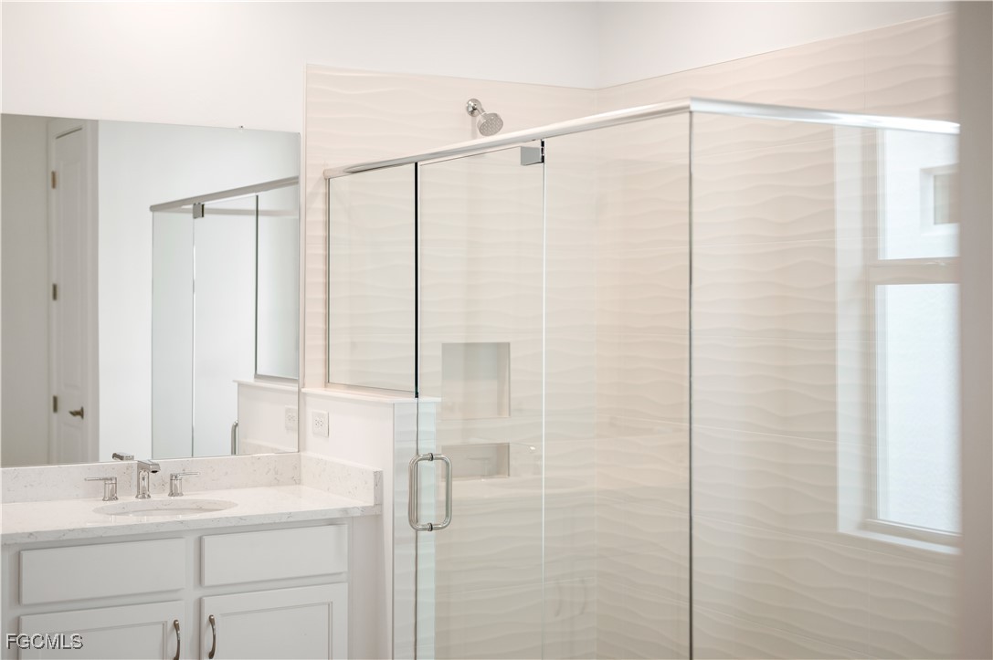 16236 Wax Myrtle Street Punta Gorda, FL 33982 - Photo 14 of 37 a bathroom with a shower sink and vanity