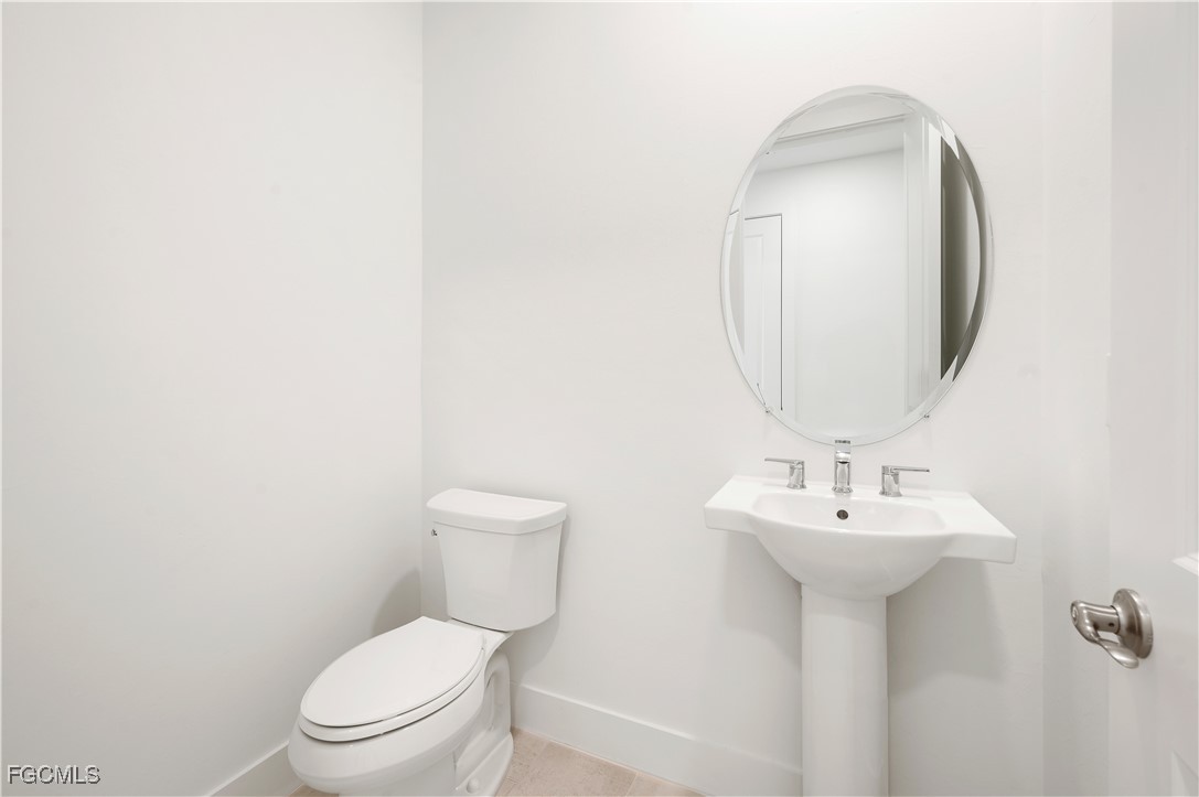 16236 Wax Myrtle Street Punta Gorda, FL 33982 - Photo 20 of 37 a white toilet sitting next to a bathroom sink