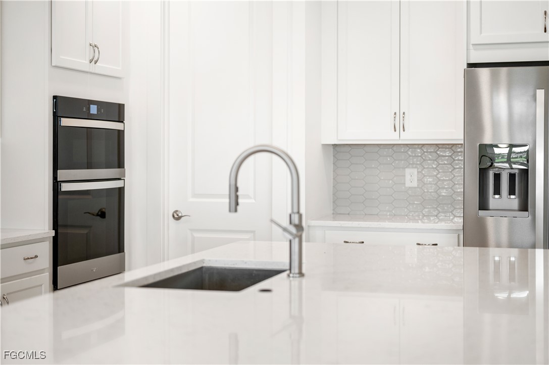 16236 Wax Myrtle Street Punta Gorda, FL 33982 - Photo 9 of 37 a kitchen with a sink and cabinets