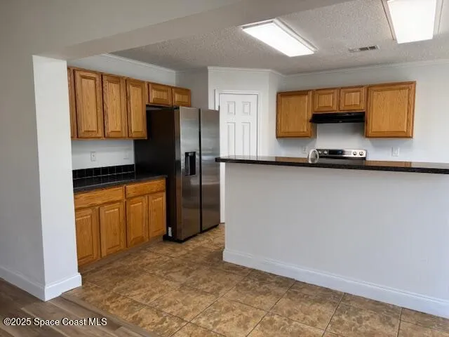 a kitchen with stainless steel appliances a refrigerator sink and stove