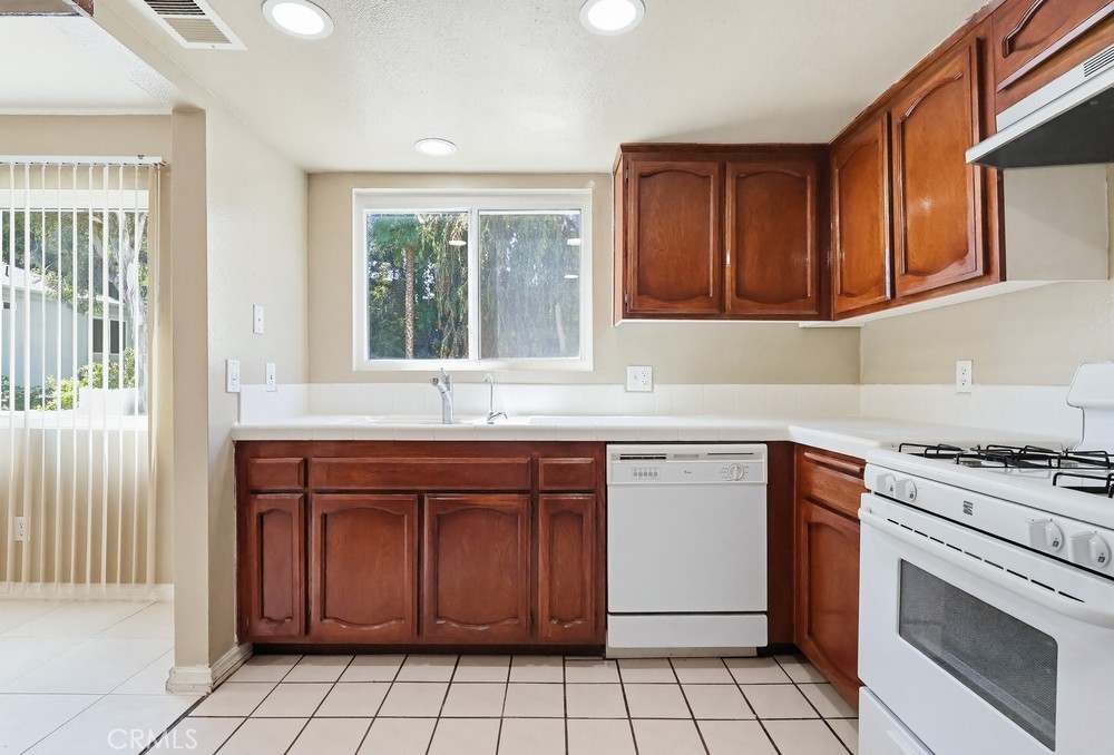 19018 Sherman Way, Unit 110 Reseda, CA 91335 - Photo 18 of 68 a kitchen with granite countertop a stove sink and cabinets