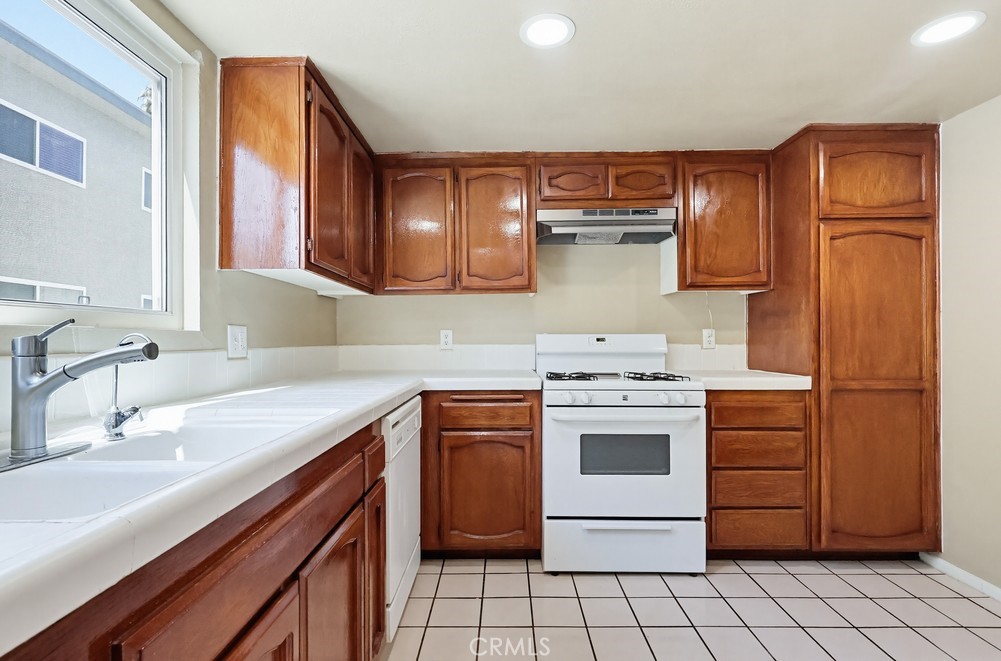 19018 Sherman Way, Unit 110 Reseda, CA 91335 - Photo 19 of 68 a kitchen with a stove sink and cabinets