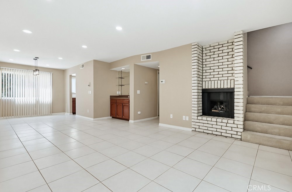 19018 Sherman Way, Unit 110 Reseda, CA 91335 - Photo 9 of 68 a view of an empty room with a fireplace and a window