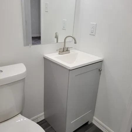 a bathroom with a sink a toilet and a mirror