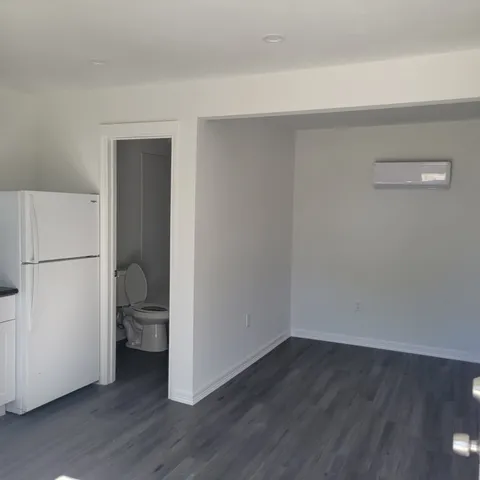 a view of a room with wooden floor and a sink