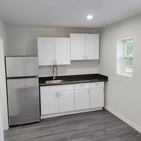 a kitchen with granite countertop white cabinets and white appliances