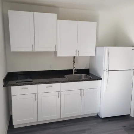 a kitchen with granite countertop white cabinets and white appliances